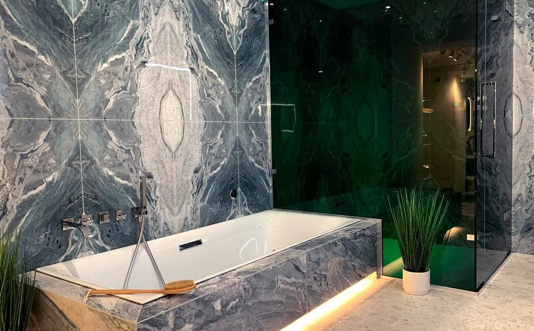 Stylish bathroom featuring marble walls, a modern bathtub, and contemporary lighting.