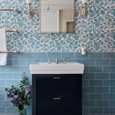 Modern bathroom featuring floral tiles, a mirror, and a dark cabinet with a sink.