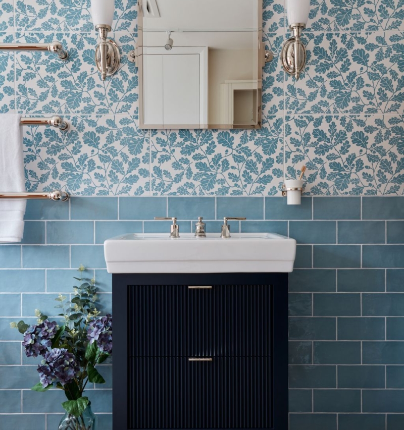 Modern bathroom featuring floral tiles, a mirror, and a dark cabinet with a sink.