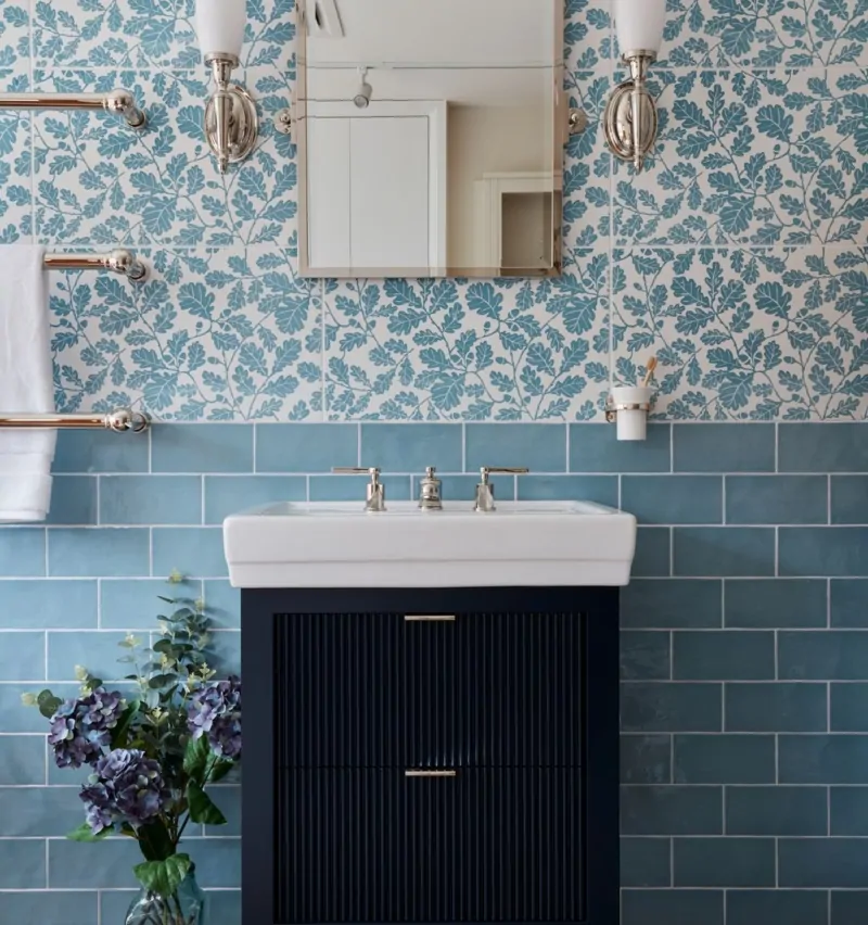Modern bathroom featuring floral tiles, a mirror, and a dark cabinet with a sink.