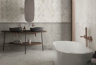 Bathroom with two black sinks, wooden counter, patterned tiles, and a freestanding bathtub.