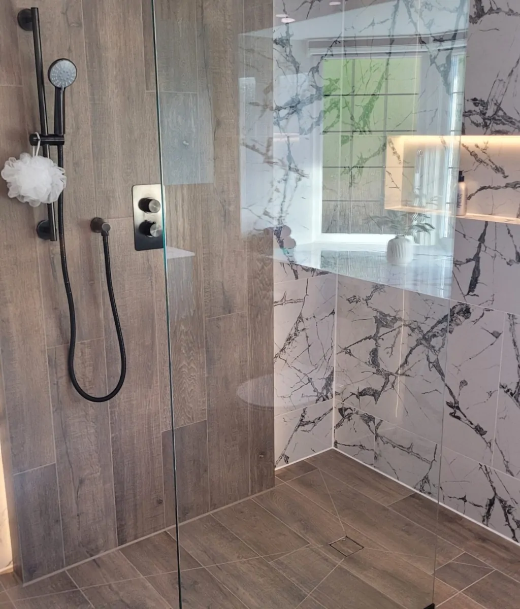 spacious walk-in shower with wood-effect tiles, marble feature walls, and a black rainfall showerhead