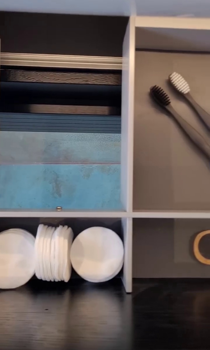 Metal grooved drawer unit supporting a white washbasin, complemented by an elegant chrome industrial faucet