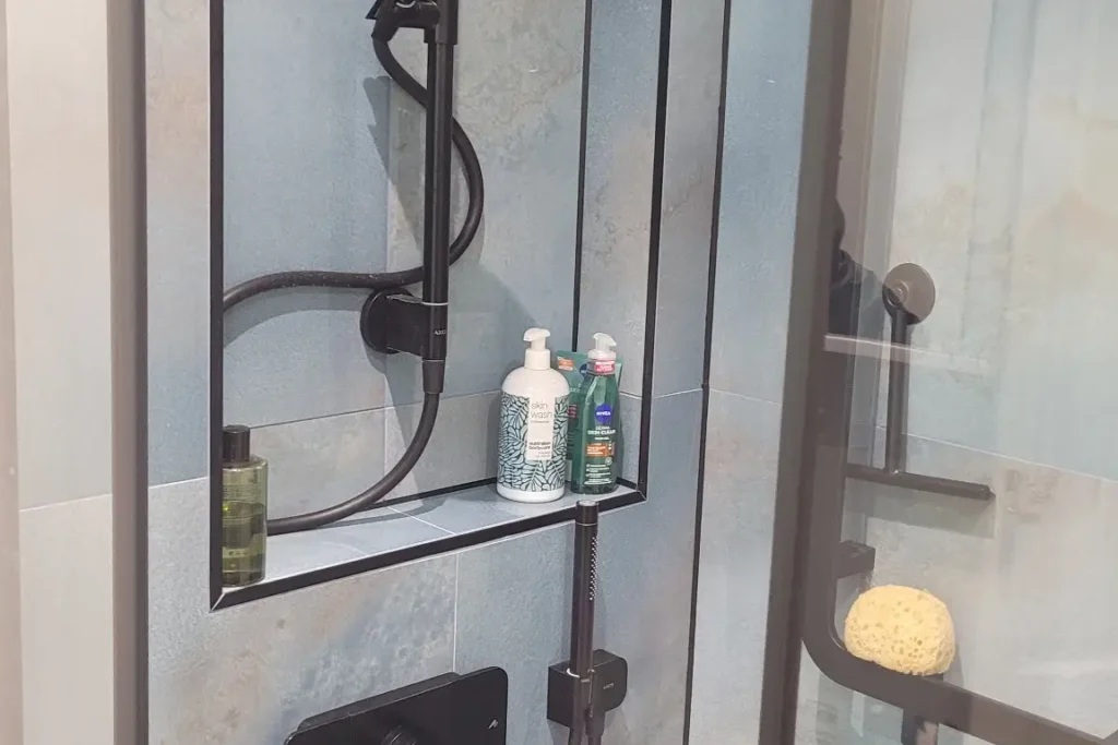 Black showerhead against a blue textured wall panel
