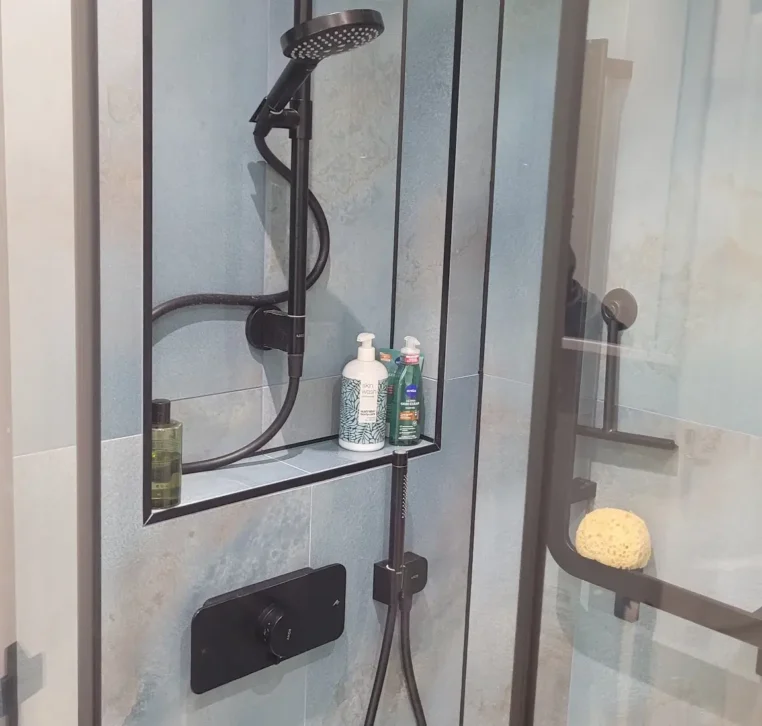 Black showerhead against a blue textured wall panel