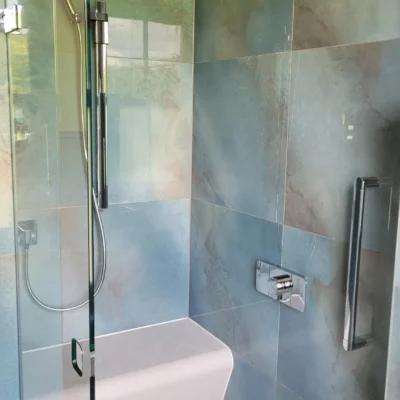 Walk-in shower with rainfall head and integrated bench.