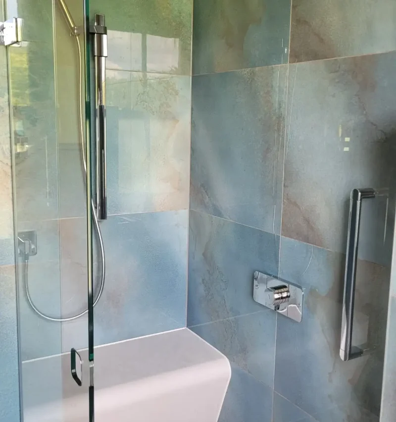 Walk-in shower with rainfall head and integrated bench.