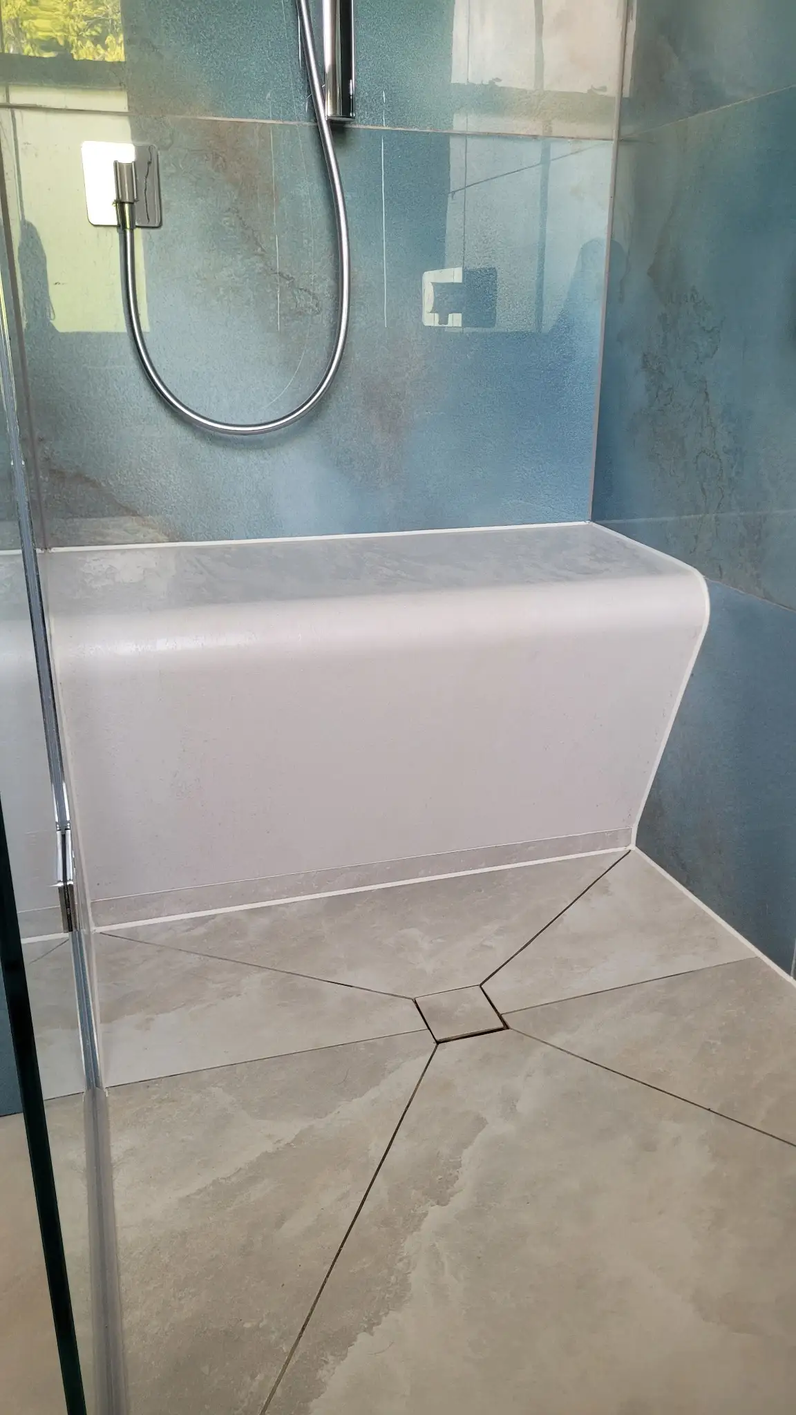 Shower bench and floor with large format tiles and centre drain