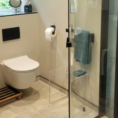 Floating toilet, vanity unit and glass shower in modern bathroom