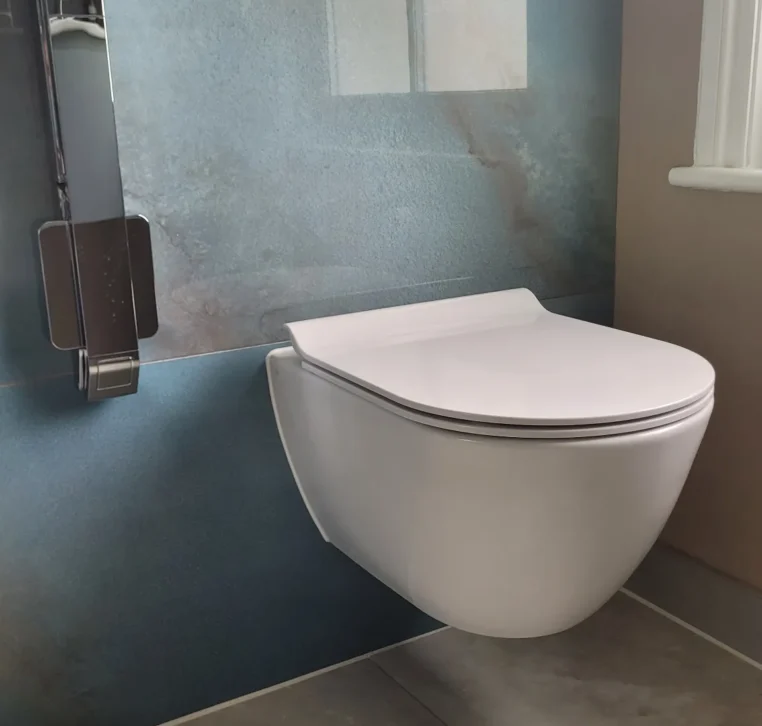 Modern floating toilet installed on blue tile wall