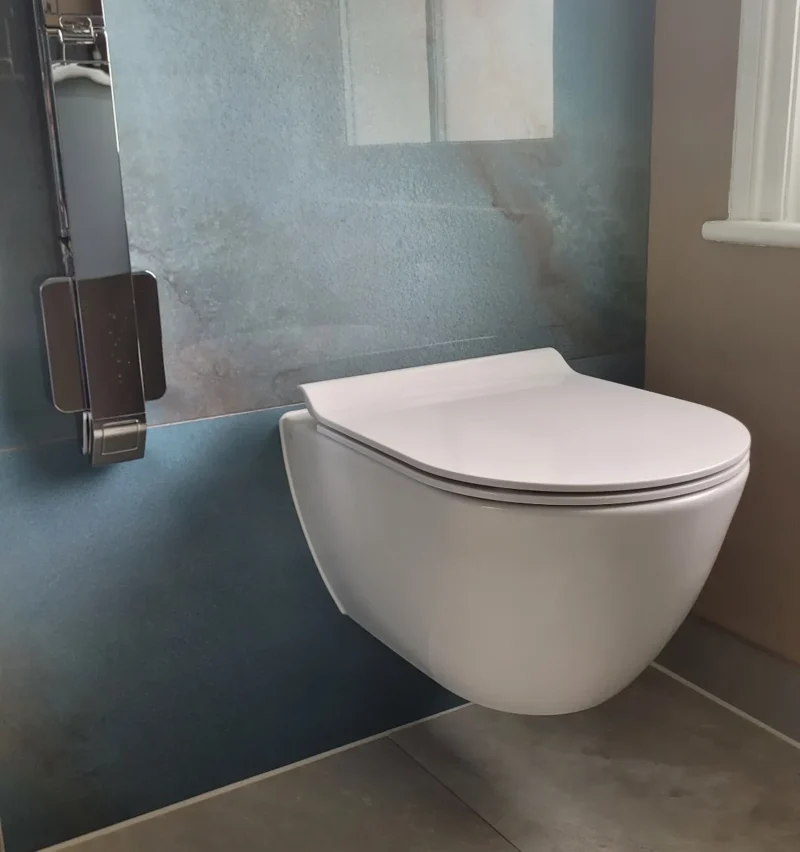 Modern floating toilet installed on blue tile wall