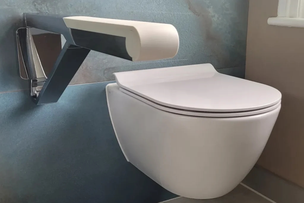 Floating toilet with modern white grab bar on blue wall.