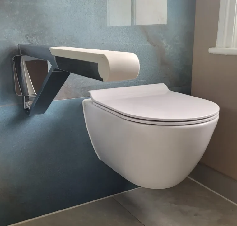 Floating toilet with modern white grab bar on blue wall.