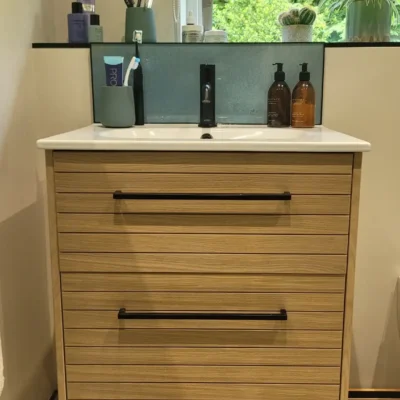Oak vanity unit with white basin and black tap under window