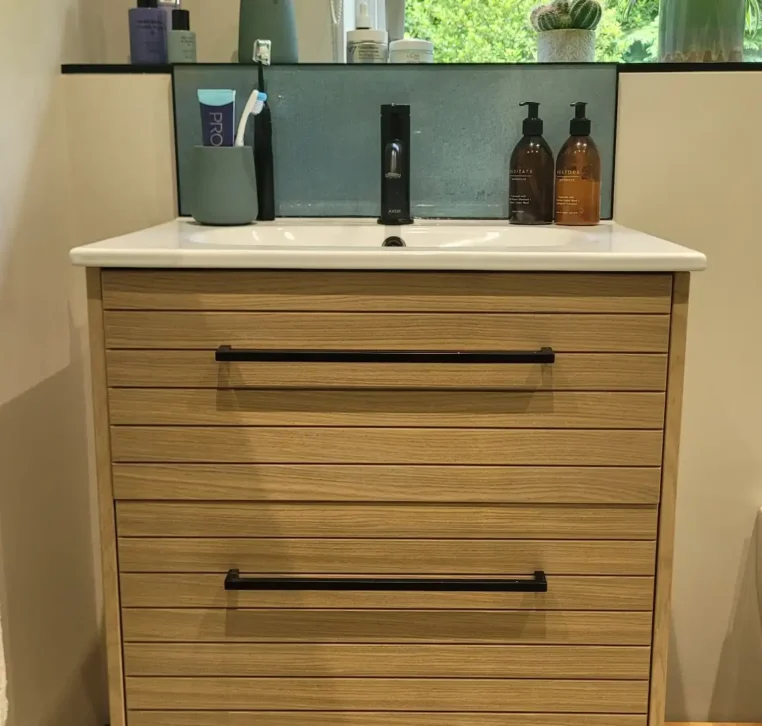 Oak vanity unit with white basin and black tap under window