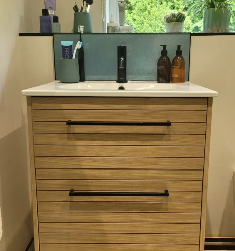 Oak vanity unit with white basin and black tap under window
