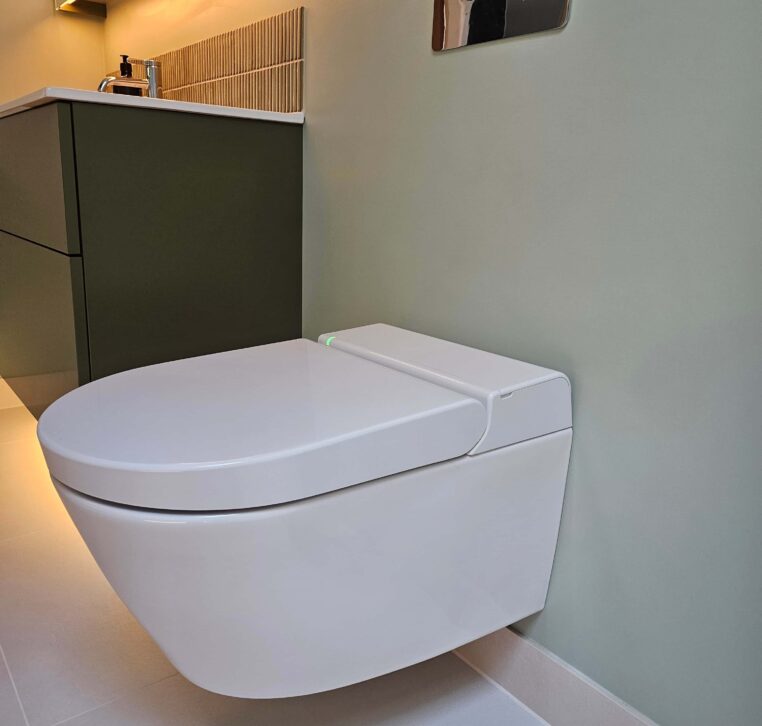 Close-up of the smart electronic WC in a high-end wetroom, with sophisticated lighting and tiles.