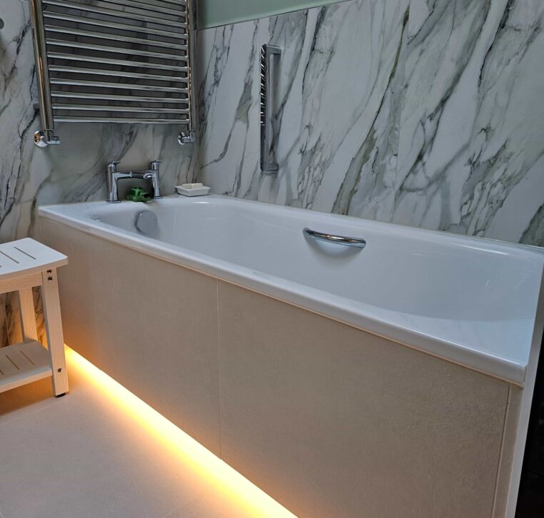 Stylish bathroom with LED up and down lighting, showcasing the bath area and smart WC in a wetroom design.
