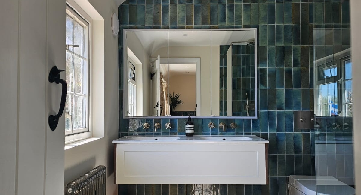 Spacious en-suite wet room with blue tiled walls, floating vanity and wall-hung toilet