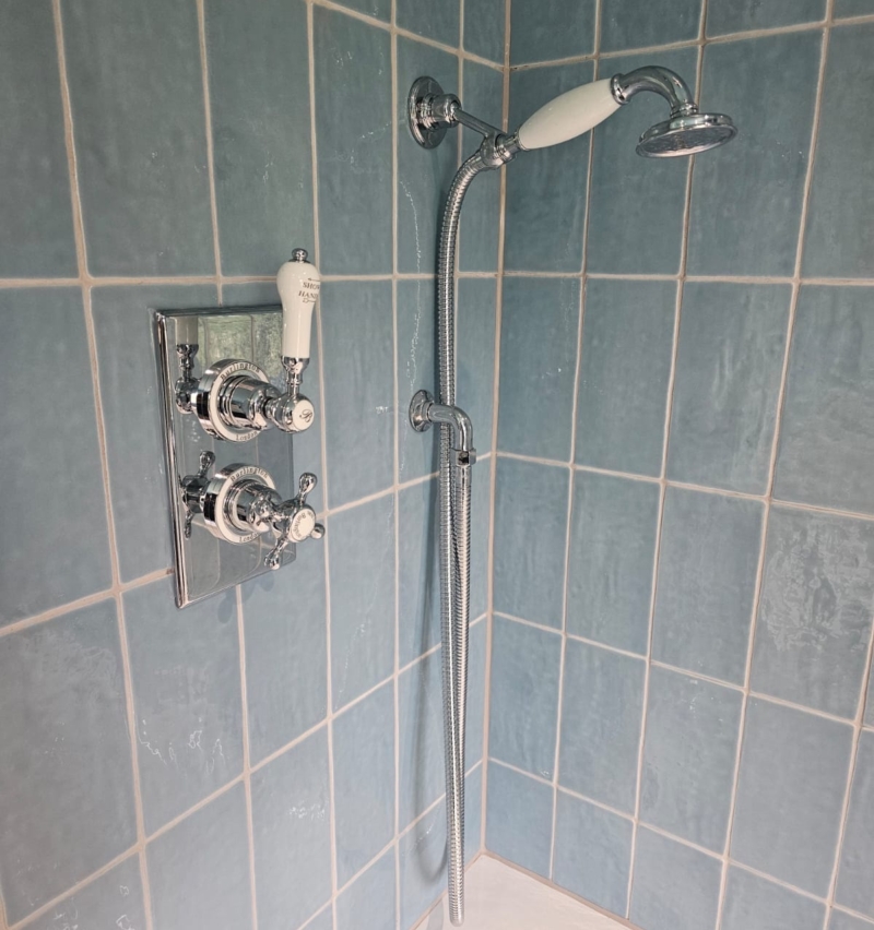 Chrome shower fittings against blue glazed wall tiles