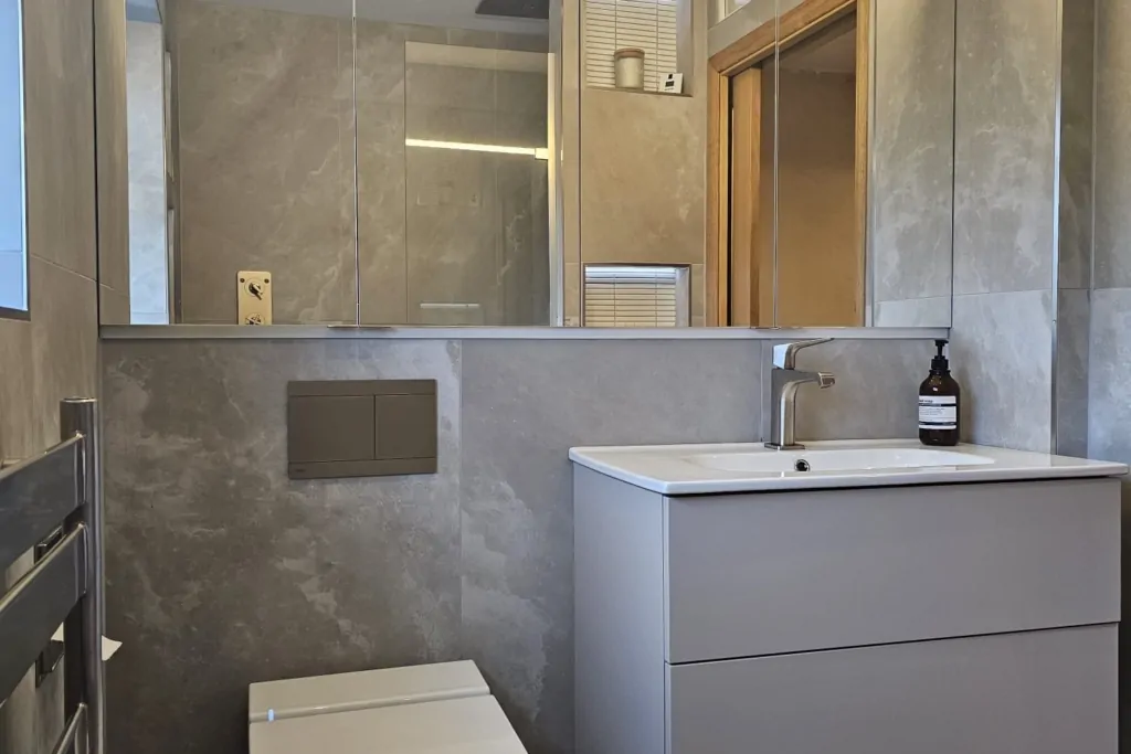 Compact bathroom with wall-hung toilet, floating vanity and illuminated mirror