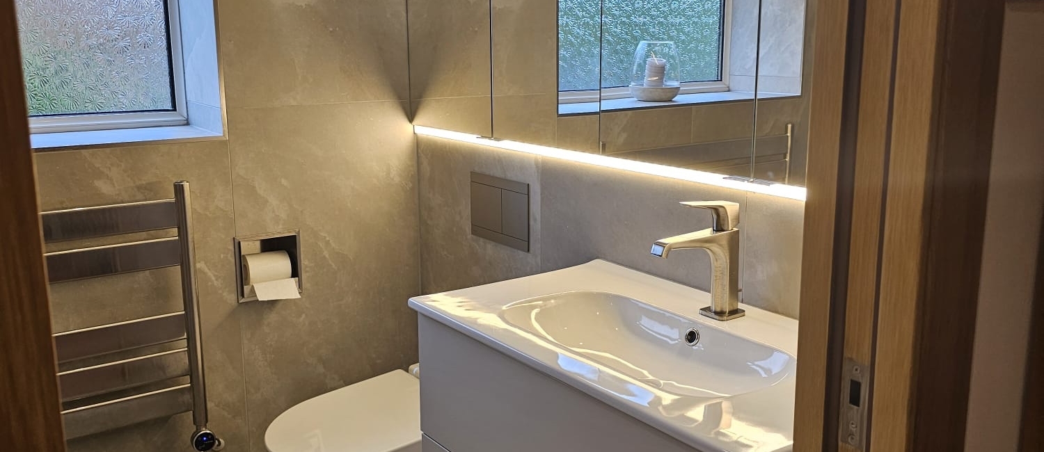 Contemporary grey bathroom with wall-hung vanity, basin and illuminated mirror