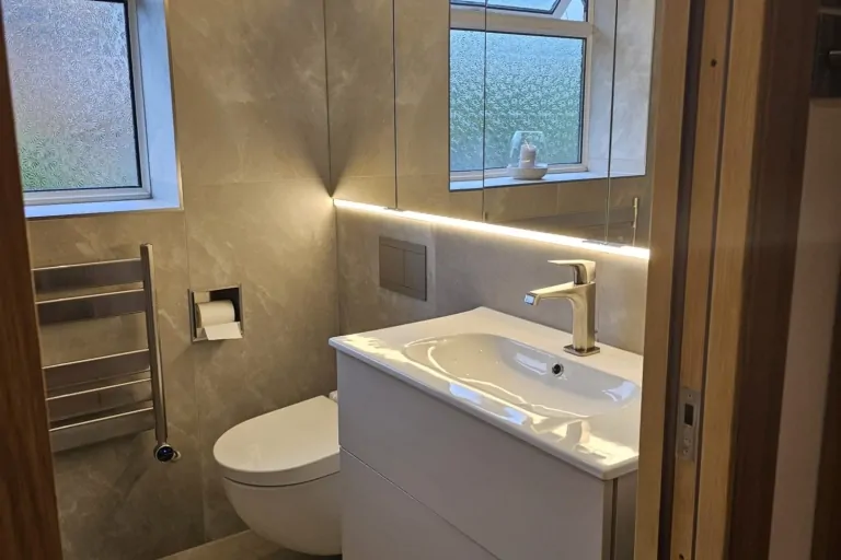 Contemporary grey bathroom with wall-hung vanity, basin and illuminated mirror
