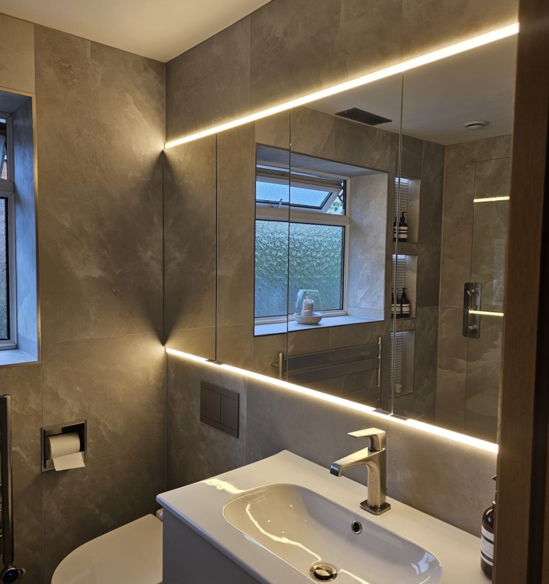Contemporary wet room with illuminated mirror, vanity unit and window