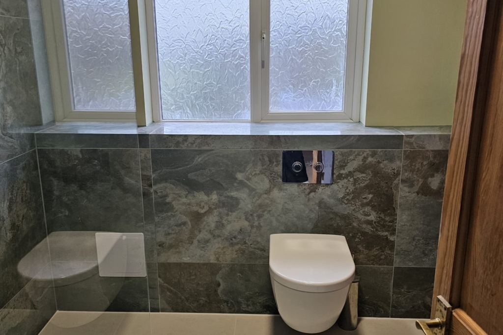 Modern green wet room with walk-in shower, wall-hung toilet and window